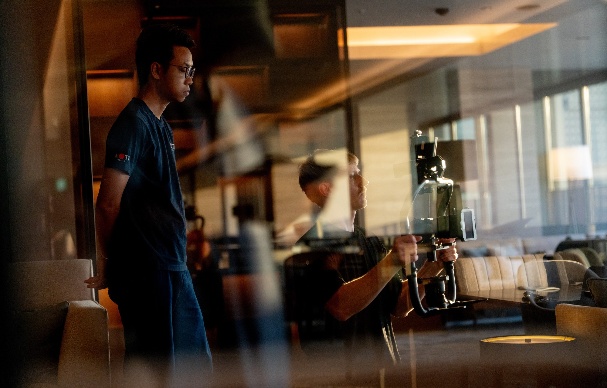 A Mott Visuals crew member works beside a camera during the hotel video production in Yokohama, Japan.
